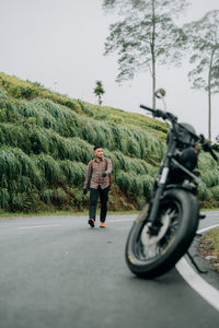 Rear view of man riding motorcycle on road