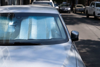 Protective reflective surface under windshield of car on hot day, heated by sun's rays inside car