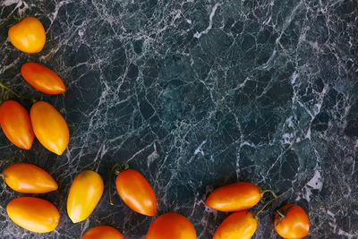 Harvesting bright orange and yellow tomatoes on green marble background. natural, grown at home food