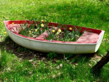 Abandoned boat moored in grass