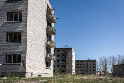 Low angle view of abandoned buildings against blue sky