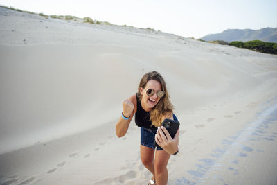 Young woman with mobile cell phone is excited and joy