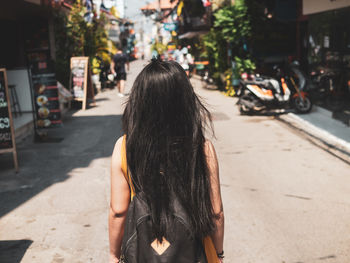 Rear view of woman walking on street in city