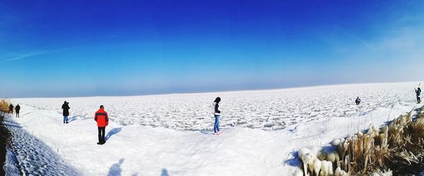 People against clear blue sky during winter