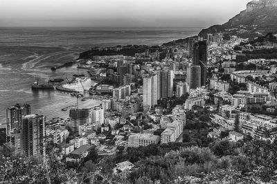 High angle view of city by sea against sky