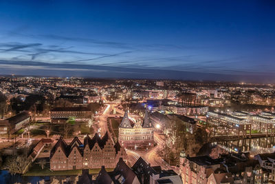 High angle view of city lit up at night