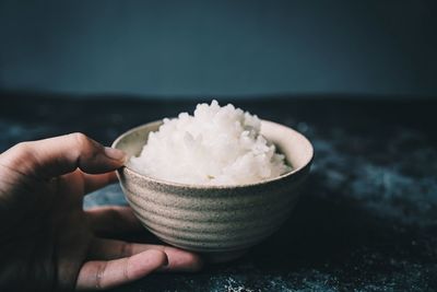 Close-up of hand holding ice cream in bowl