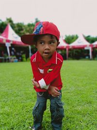 Portrait of boy standing on grassy field