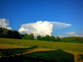 Scenic view of grassy field against cloudy sky