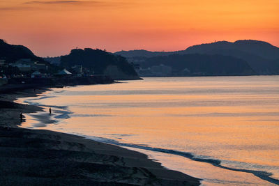 Scenic view of sea against orange sky during sunrise