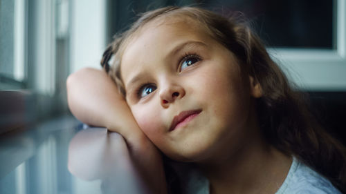 Close-up portrait of cute girl at home