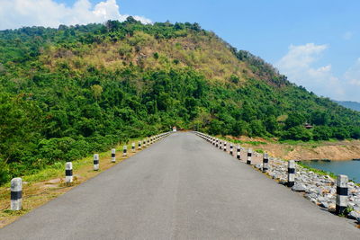 Road amidst trees against sky