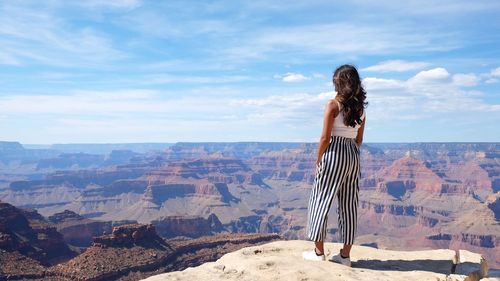 Woman standing on mountain against sky