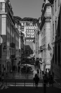 People walking on road along buildings