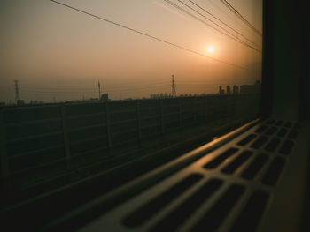 Railroad tracks against sky during sunset