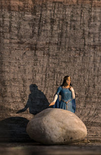 Full length portrait of woman sitting outdoors