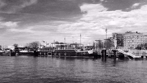 View of fishing boats moored at harbor against sky