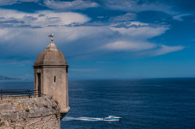 Scenic view of sea by building against sky