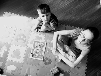 High angle portrait of mother and daughter on floor