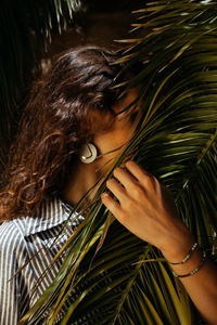 Close-up portrait of woman holding palm leaf