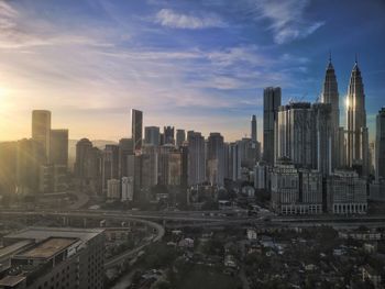 Buildings in city against cloudy sky