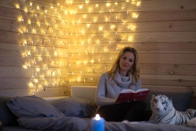 Young beautiful girl reading a book on the couch.