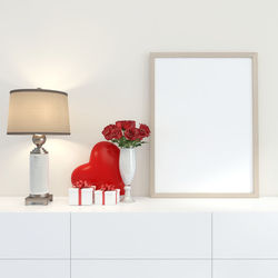 Red and white vase on table against wall at home