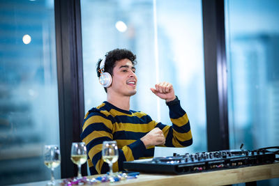 Smiling young man with drink on table