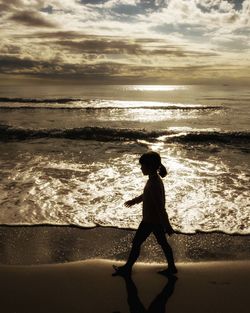 Full length of girl on beach against sky