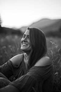 Portrait of a smiling young woman sitting on land