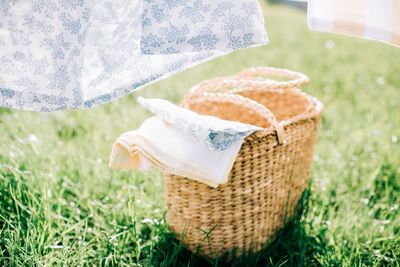 Wicker basket filled with linen on the grass for washing