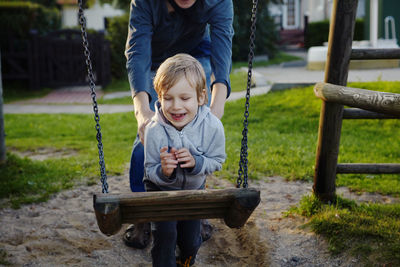 Low section of father playing son in yard