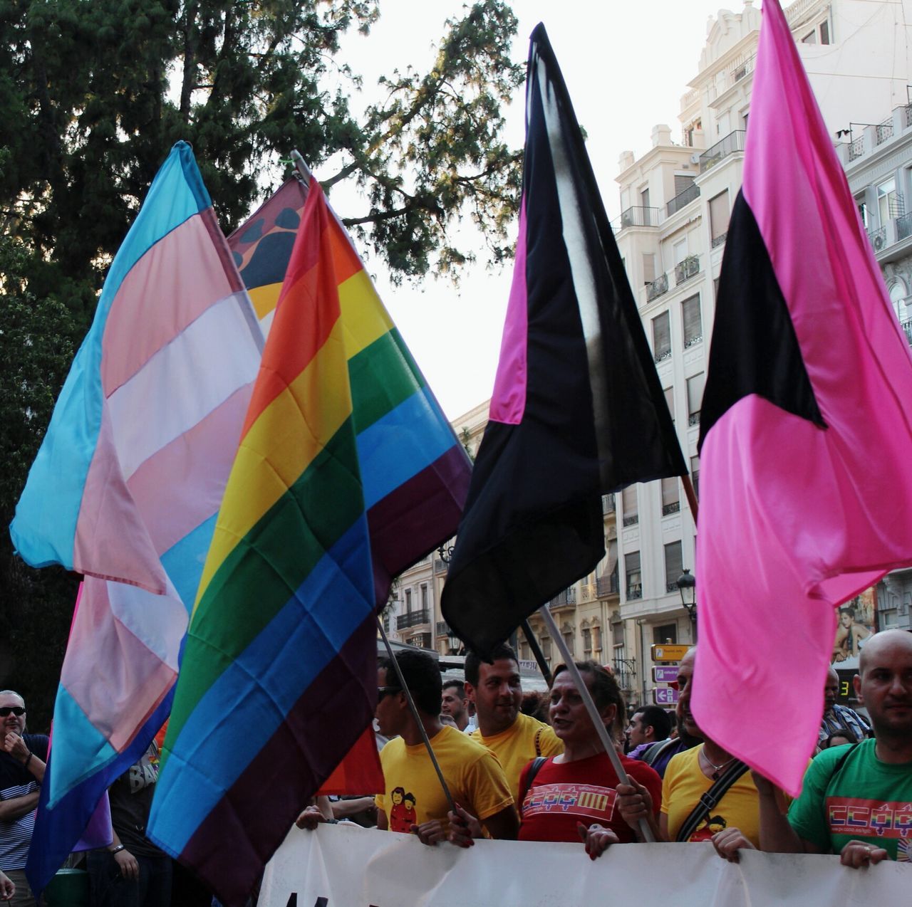 flag, patriotism, identity, national flag, multi colored, american flag, hanging, umbrella, sky, low angle view, culture, wind, day, celebration, colorful, large group of people, pride, cultures, men