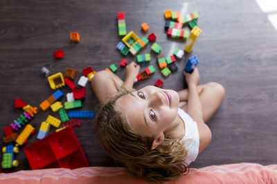 High angle portrait of girl playing with toy blocks while sitting on floor