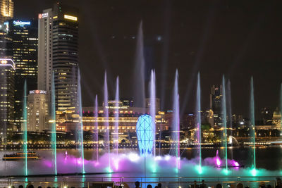 Illuminated buildings against sky at night