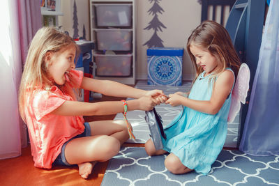 Two little mad angry girls sisters having fight at home. friends girls can not share toy. 