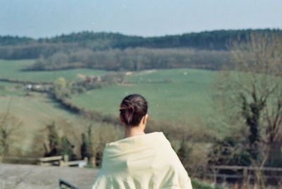 Rear view of woman on field against sky