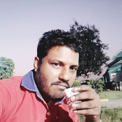 Portrait of young man drinking glass