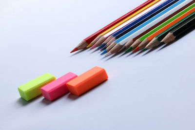 Close-up of colored pencils over white background