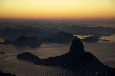 Aerial view of sugarloaf mountain in sea against sky during sunrise