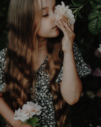Midsection of young girl smelling a rose