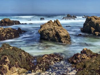 Beautiful rocky coastline landscape of waves crashing on beach along pacific groves scenic drive.