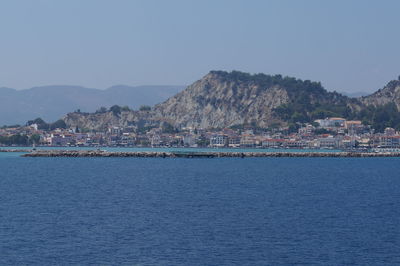 Scenic view of sea and mountains against clear sky