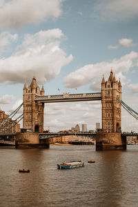 Bridge over river against cloudy sky