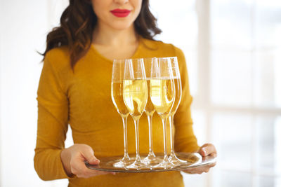 Midsection of woman serving champagne in party