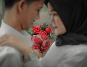 Midsection of woman holding rose bouquet