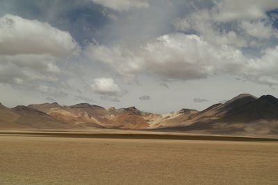 View of desert against cloudy sky