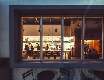 Reflection of illuminated glass window on table in restaurant