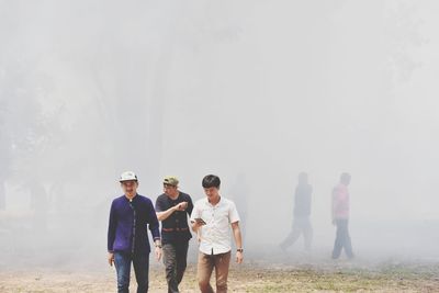 Men walking on field during foggy weather