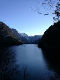 Scenic view of lake and mountains against clear blue sky